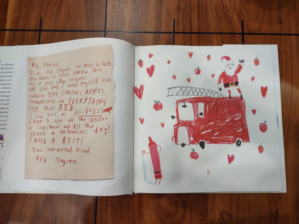 letter from red crayon with drawing of a fire truck, santa, apples and hearts